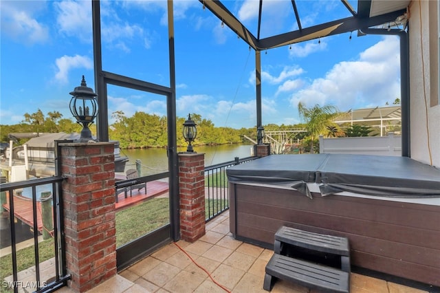 view of patio / terrace with a water view and a hot tub