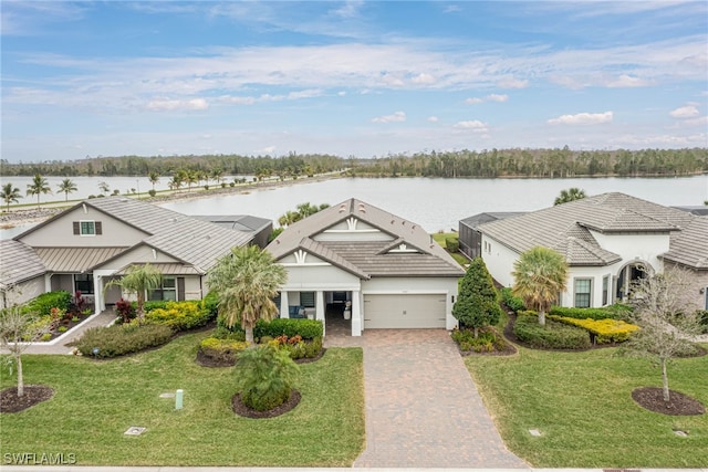 view of front of property with a garage, a front yard, and a water view