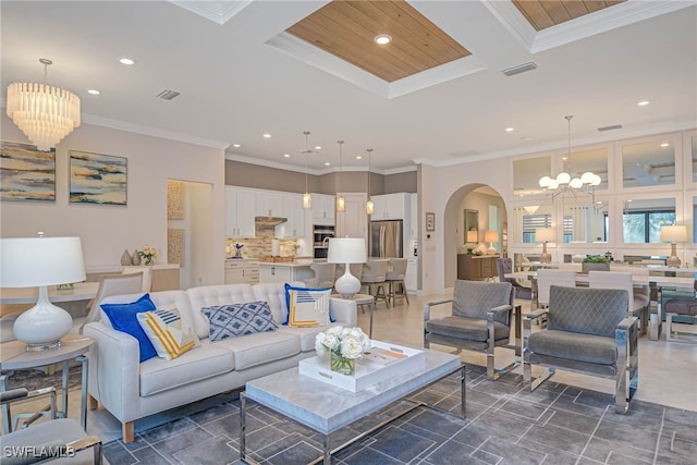 living room featuring an inviting chandelier, ornamental molding, and coffered ceiling