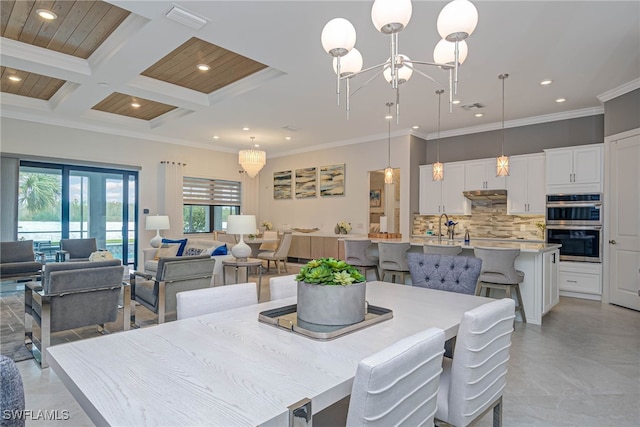 dining room featuring an inviting chandelier, crown molding, and coffered ceiling