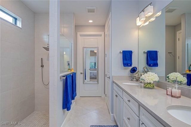 bathroom featuring vanity, tile patterned floors, and a tile shower