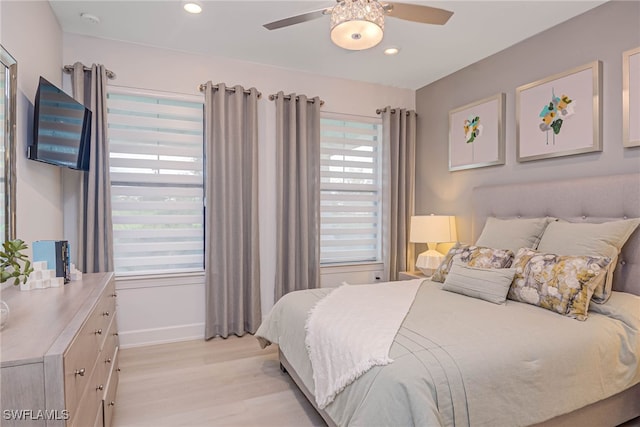 bedroom with ceiling fan, light hardwood / wood-style flooring, and multiple windows