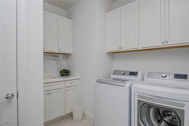 laundry area featuring sink, independent washer and dryer, and cabinets