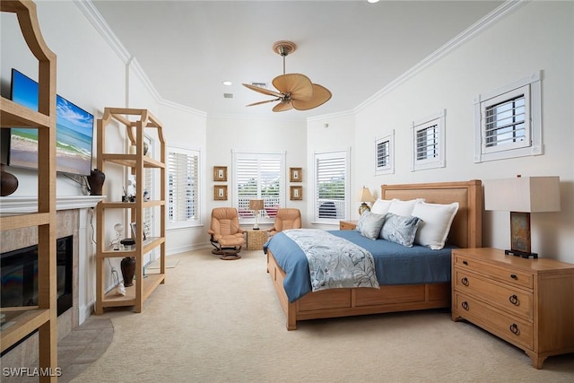 carpeted bedroom featuring ceiling fan, ornamental molding, and a tiled fireplace