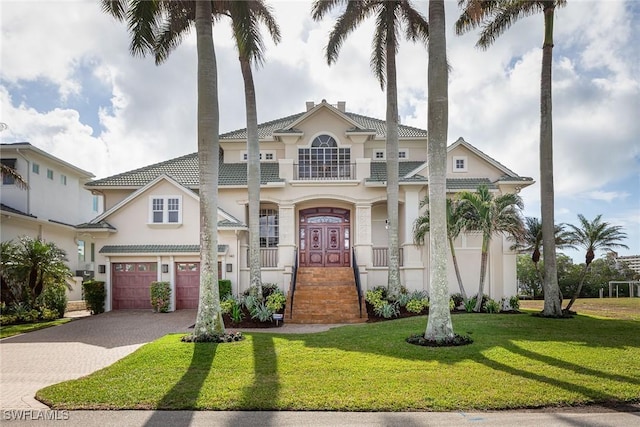 mediterranean / spanish house with a balcony, a front lawn, and a garage