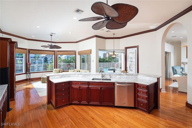 kitchen featuring light wood-type flooring, sink, pendant lighting, dishwasher, and an island with sink