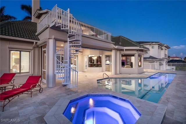 view of pool with an in ground hot tub, stairway, a patio area, and a fenced in pool