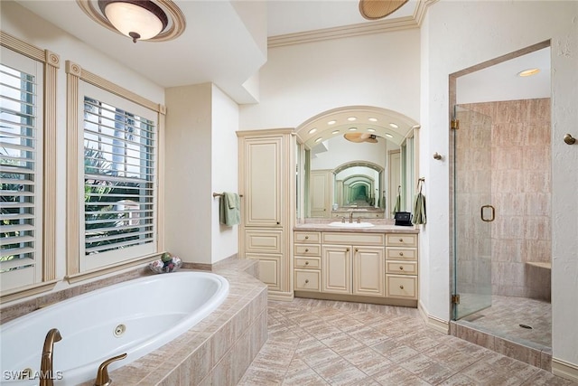 full bath with a shower stall, a tub with jets, ornamental molding, and vanity