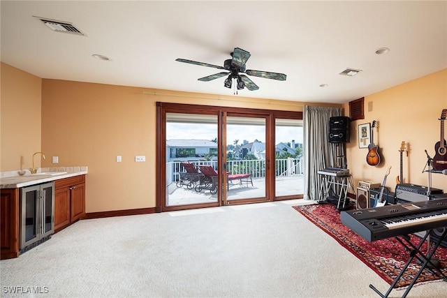 exercise area with wine cooler, a sink, visible vents, and light colored carpet