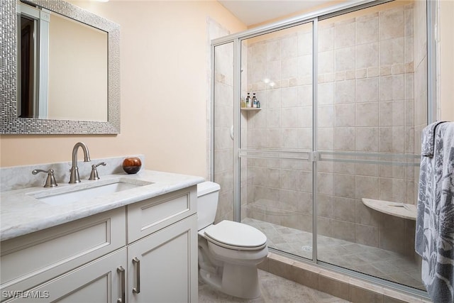 full bathroom with vanity, a shower stall, and toilet