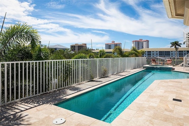 view of pool featuring a pool with connected hot tub, fence, and a patio