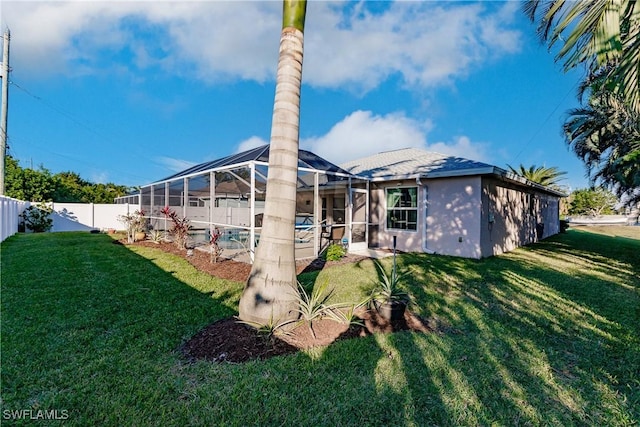 back of property with a pool, a lanai, and a lawn