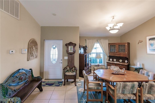 entrance foyer with light tile patterned floors and an inviting chandelier