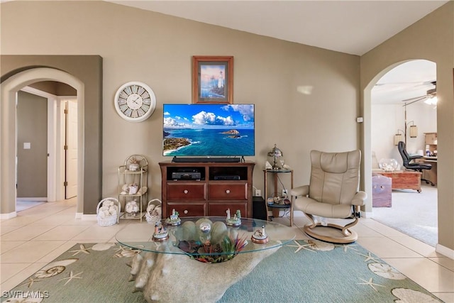 living room featuring ceiling fan, light tile patterned flooring, and lofted ceiling