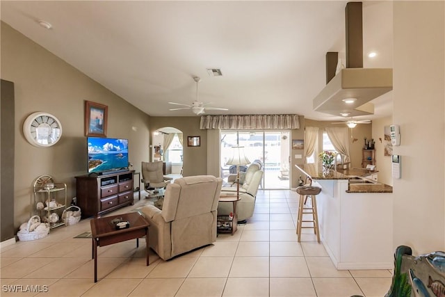 living room with light tile patterned floors, ceiling fan, and lofted ceiling