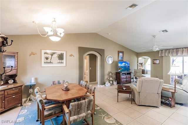 tiled dining room with lofted ceiling and ceiling fan with notable chandelier