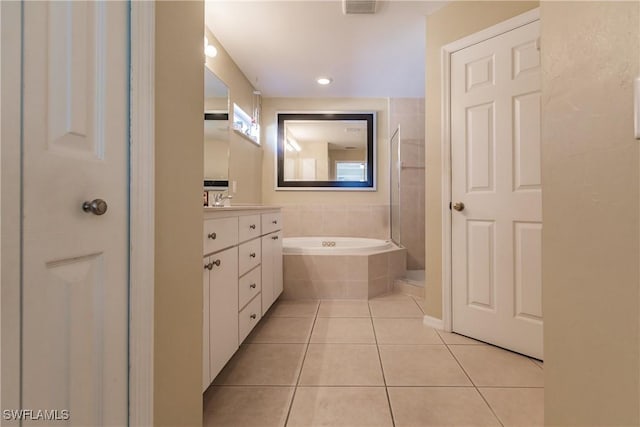 bathroom with vanity, tile patterned floors, and tiled tub