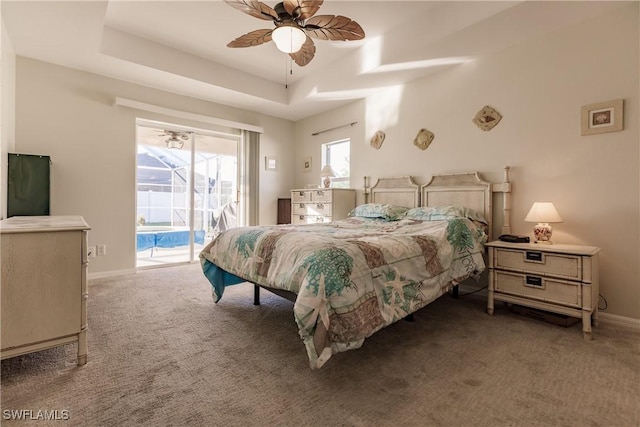 bedroom with access to exterior, ceiling fan, a raised ceiling, and carpet floors