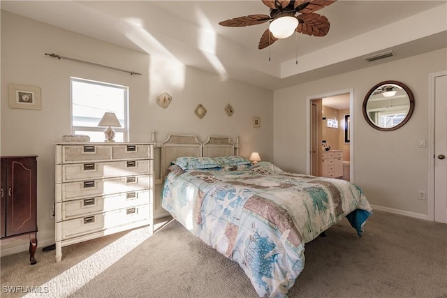 carpeted bedroom with ceiling fan and ensuite bath