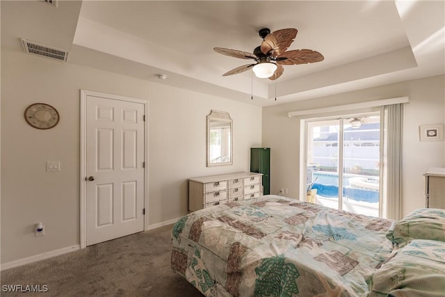 carpeted bedroom with access to exterior, a raised ceiling, and ceiling fan