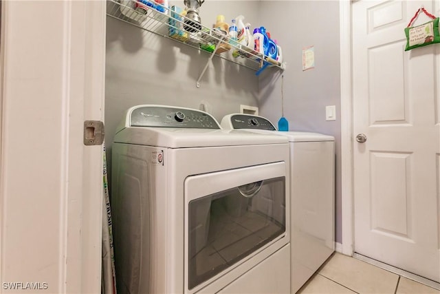 laundry room with light tile patterned floors and washing machine and clothes dryer