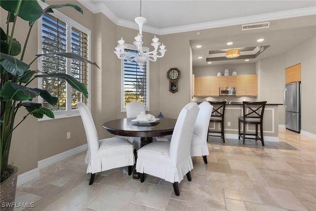 dining room with ornamental molding, a tray ceiling, and a chandelier