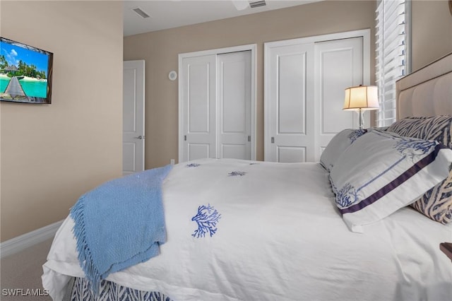 bedroom with carpet flooring and two closets