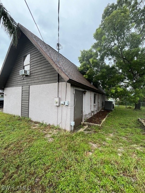 view of side of property with a lawn and central AC unit