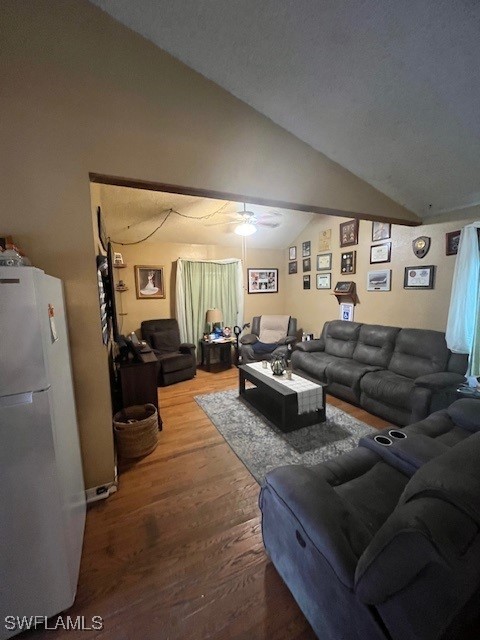 living room featuring hardwood / wood-style floors, ceiling fan, and vaulted ceiling