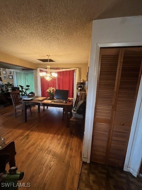 dining space featuring dark hardwood / wood-style floors, a chandelier, and a textured ceiling