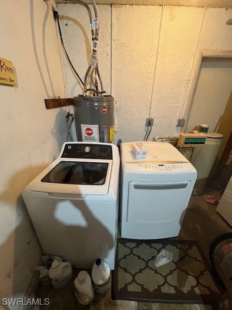 clothes washing area featuring washing machine and dryer and water heater