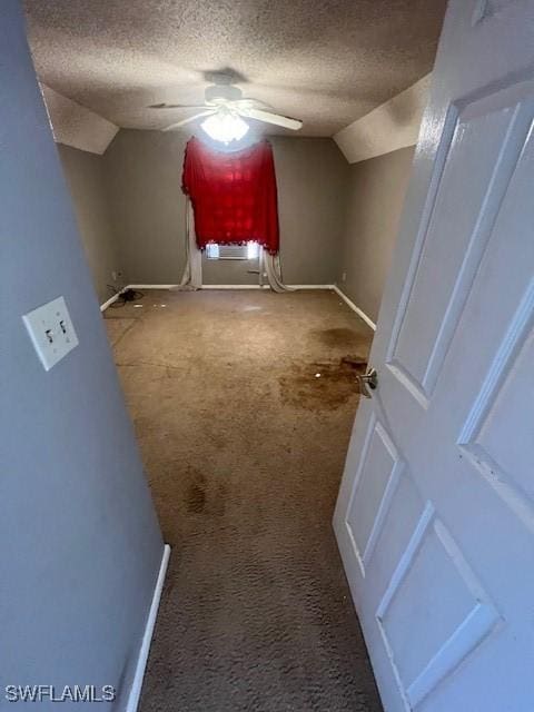 interior space with ceiling fan, lofted ceiling, a textured ceiling, and carpet floors