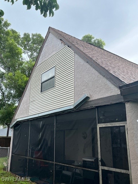 view of property exterior with a sunroom