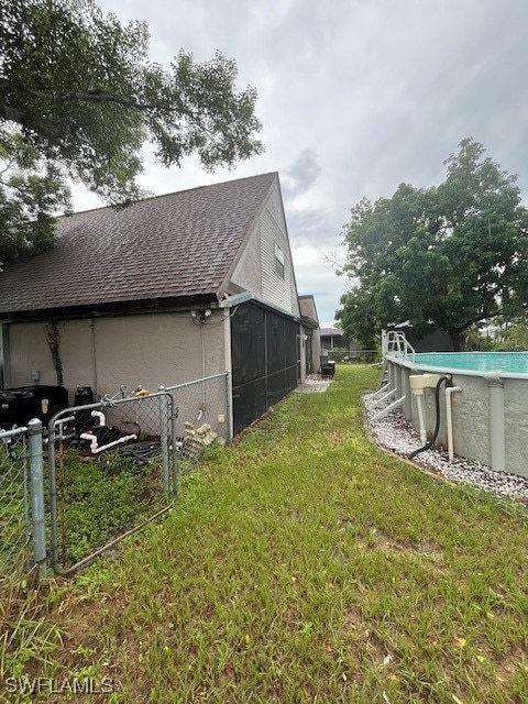 view of side of property with a sunroom and a yard