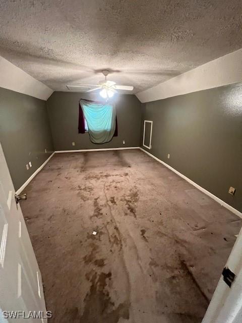 bonus room with lofted ceiling and a textured ceiling