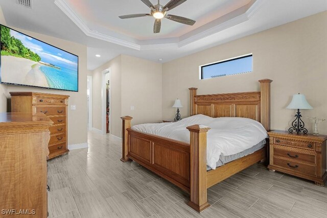 bedroom featuring a tray ceiling, ceiling fan, and crown molding