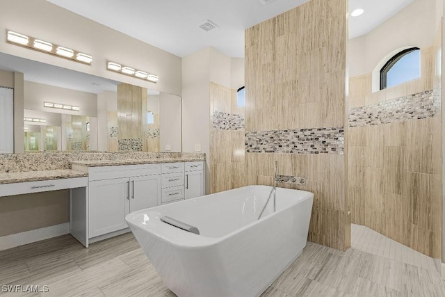 bathroom featuring vanity, tile walls, and independent shower and bath