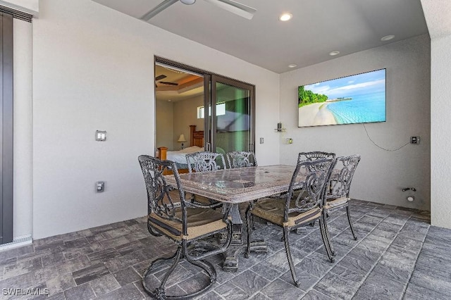 dining room with ceiling fan and a raised ceiling