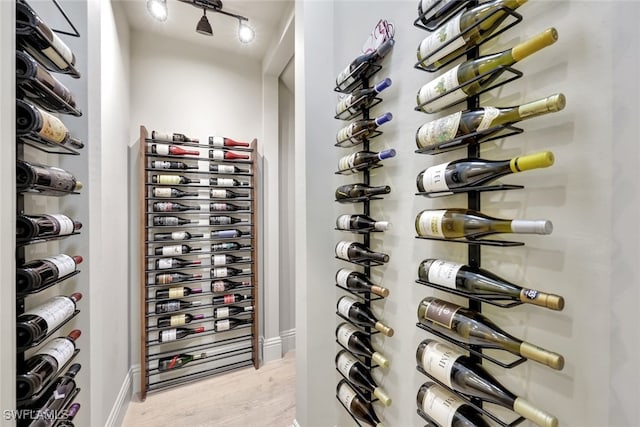 wine cellar with electric panel and light wood-type flooring