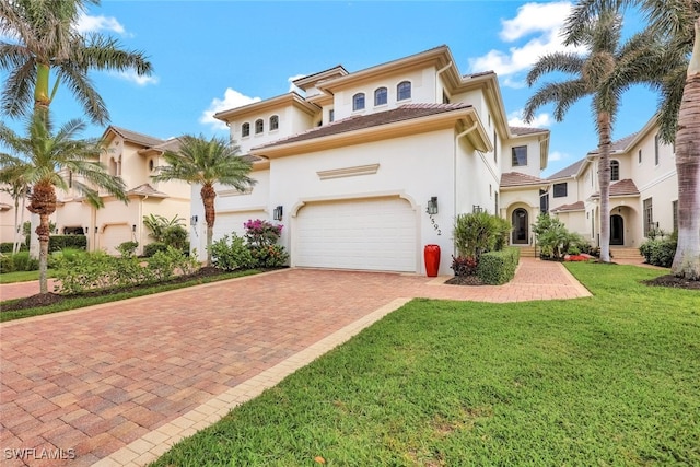 mediterranean / spanish-style home featuring a front lawn and a garage