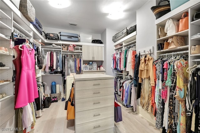 walk in closet with light wood-type flooring