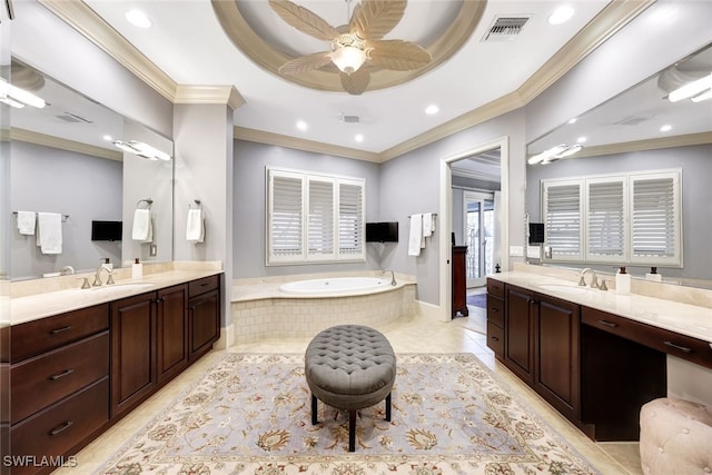 bathroom featuring ceiling fan, tiled tub, a tray ceiling, and vanity