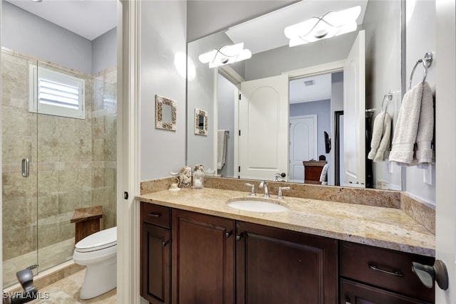 bathroom featuring toilet, vanity, tile patterned flooring, and an enclosed shower