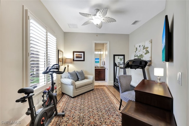 exercise area with ceiling fan and wood-type flooring