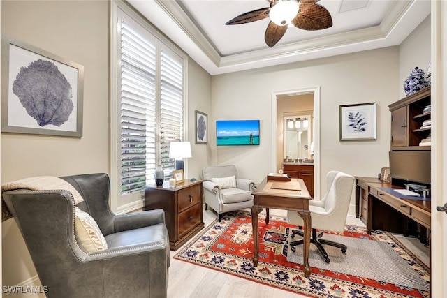 home office with a raised ceiling, ceiling fan, crown molding, and hardwood / wood-style flooring