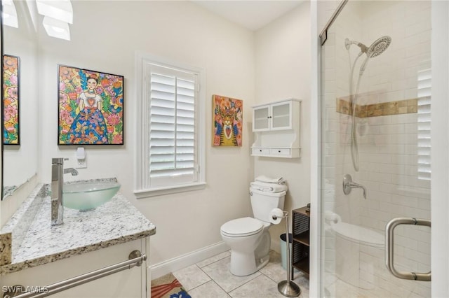 bathroom featuring tile patterned flooring, vanity, toilet, and a shower with shower door