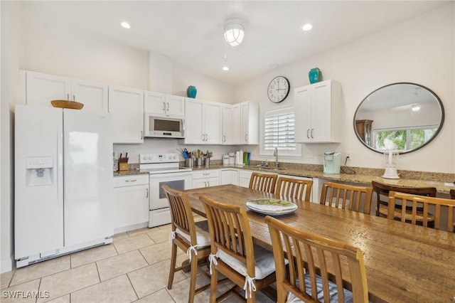 kitchen with stone countertops, white cabinetry, white appliances, and light tile patterned floors