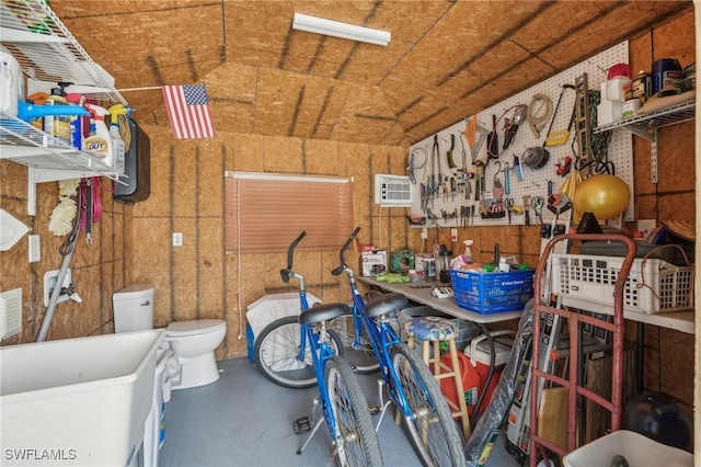 storage room featuring an AC wall unit and sink