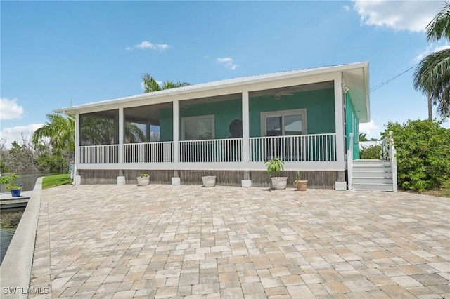 back of house featuring a sunroom, ceiling fan, and a patio