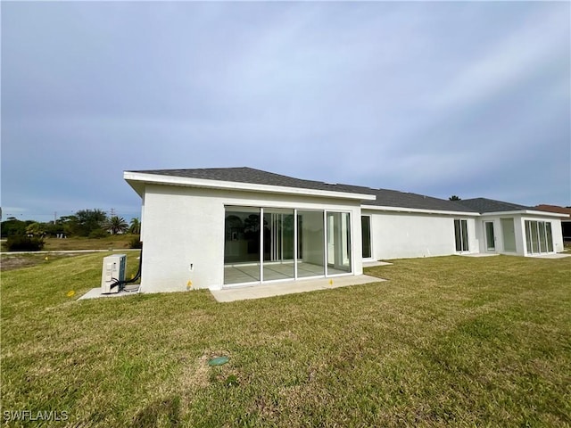 rear view of property featuring a lawn